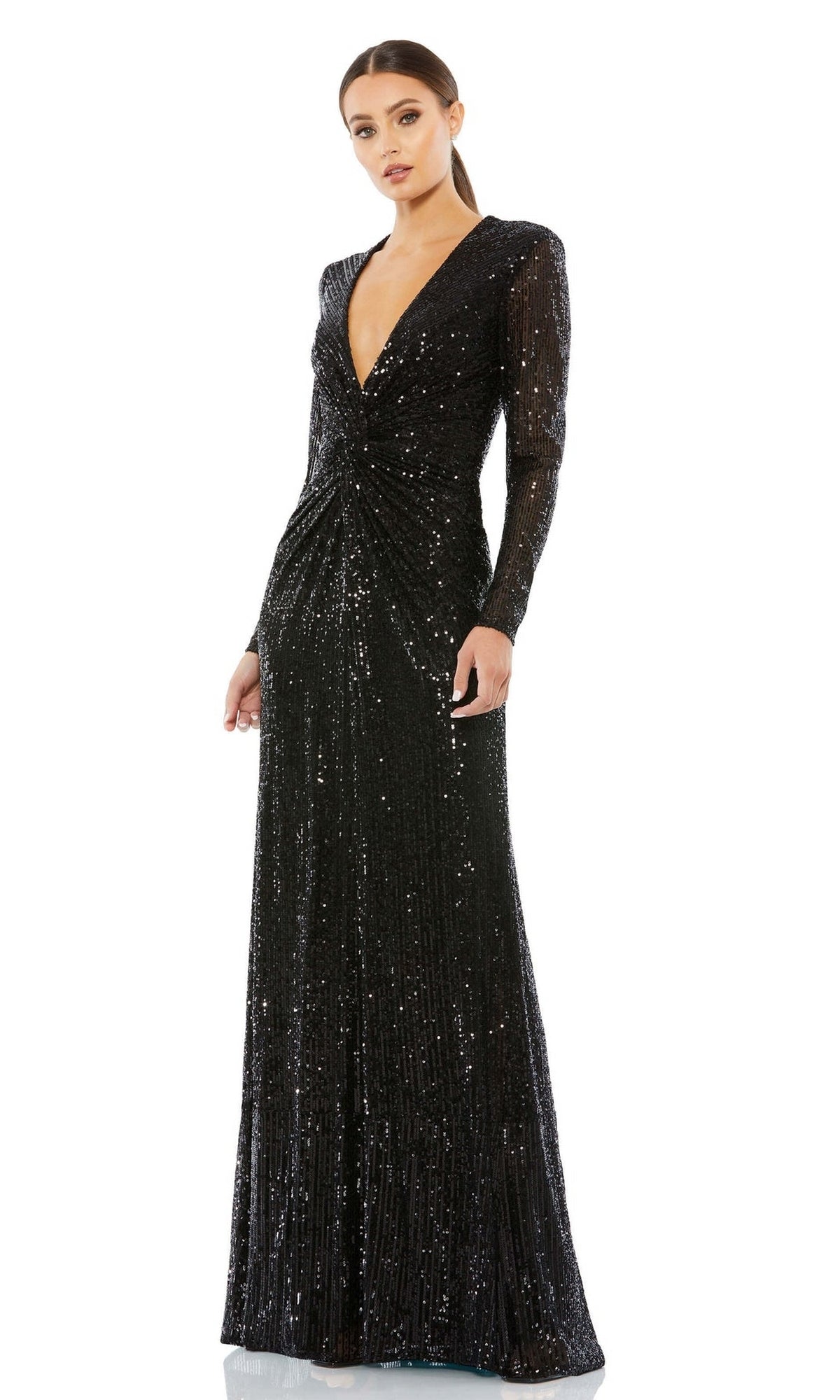 A woman models the Long Formal Dress 26552 by Mac Duggal—an elegant, floor-length black sequin gown with long sleeves, a deep V-neckline, and a gathered waist—posed against a white background.